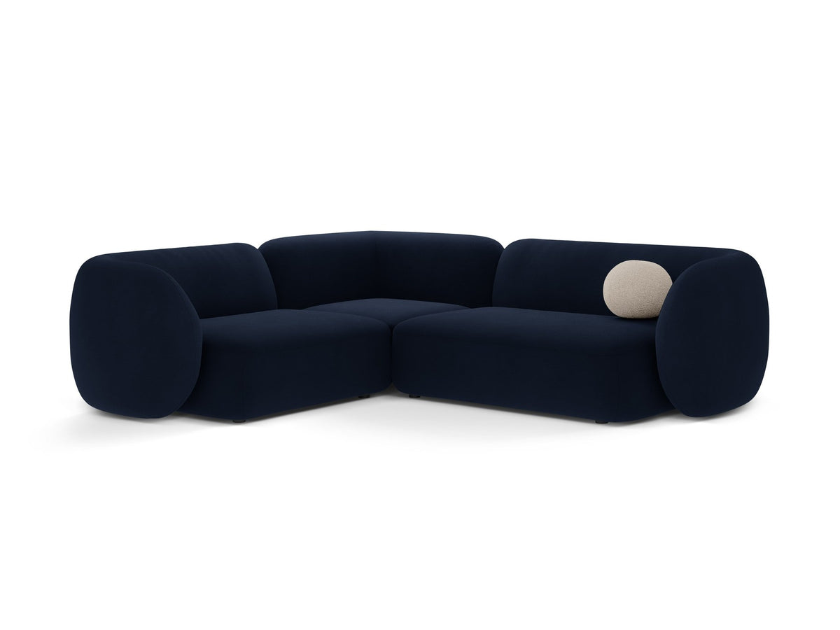 Weisses Ecksofa links Kate von Micadoni mit Bouclé-Stoff Baloo, schwarzen Kunststoffbeinen und niedriger Rückenlehne im Wohnraum.
