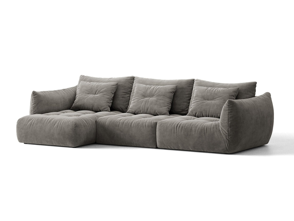Beiges L-Sofa links von Micadoni mit weichem Veloursstoff Casino, schwarzen Kunststoffbeinen und breiter, tiefer Sitzfläche.