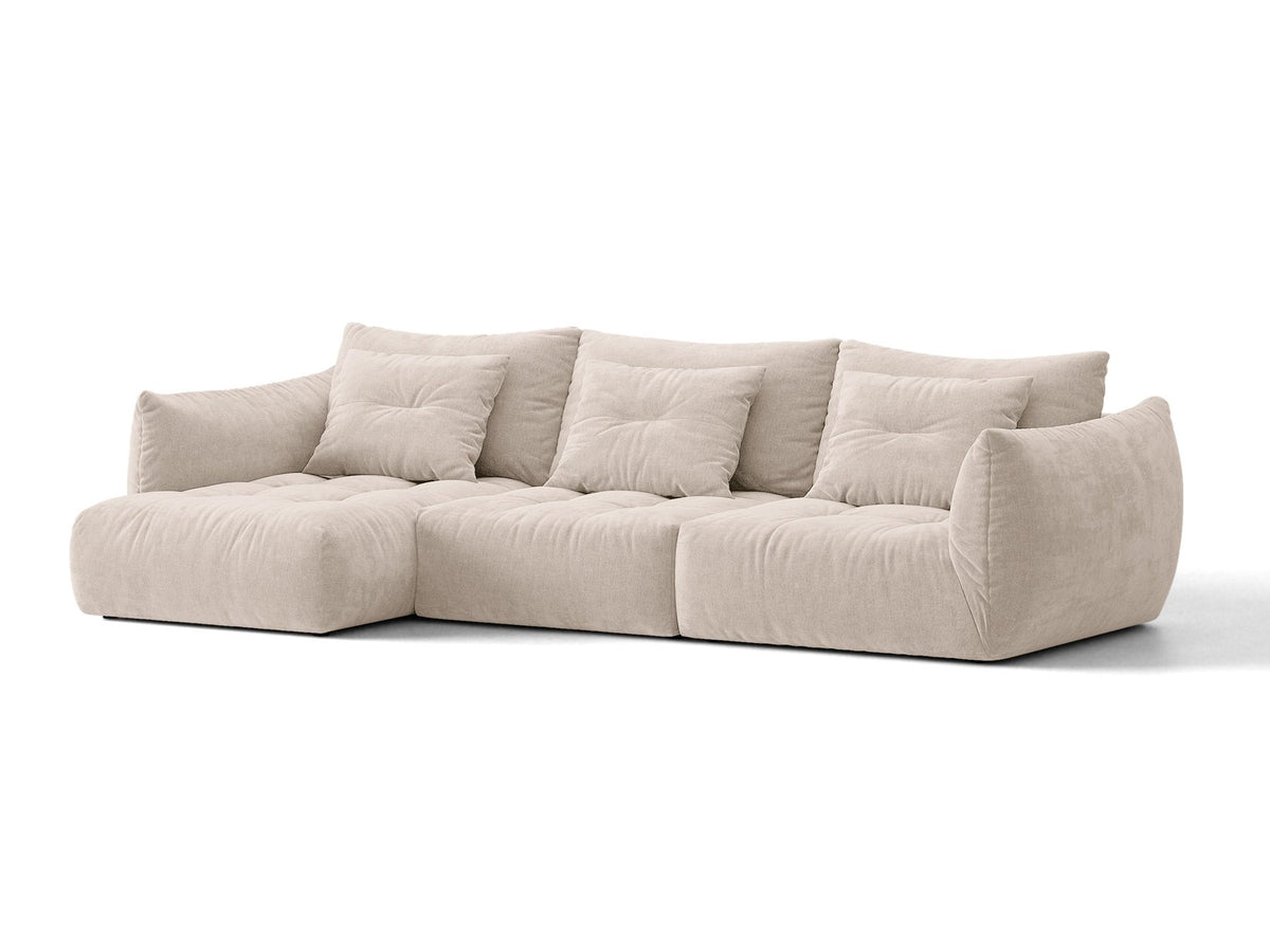 Beiges L-Sofa links von Micadoni mit weichem Veloursstoff Casino, schwarzen Kunststoffbeinen und breiter, tiefer Sitzfläche.