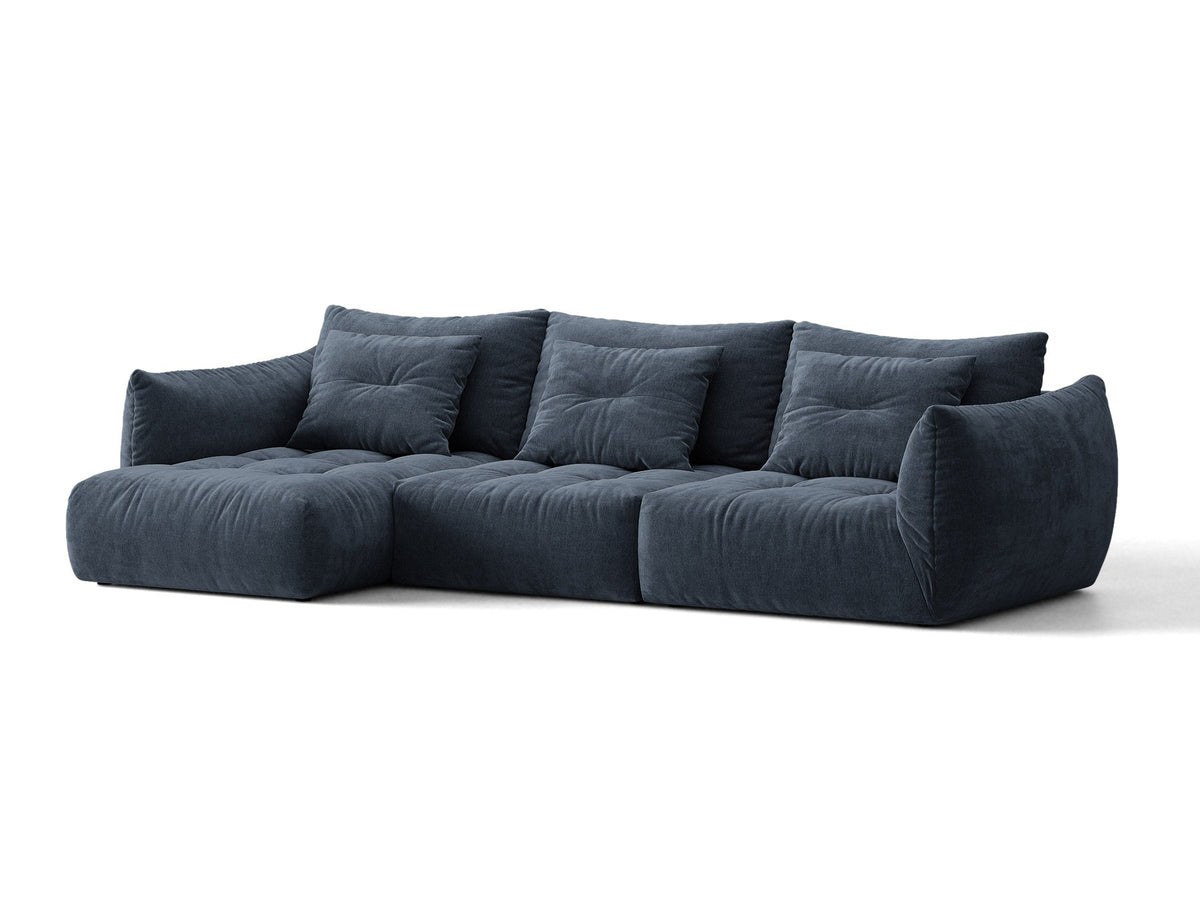Beiges L-Sofa links von Micadoni mit weichem Veloursstoff Casino, schwarzen Kunststoffbeinen und breiter, tiefer Sitzfläche.