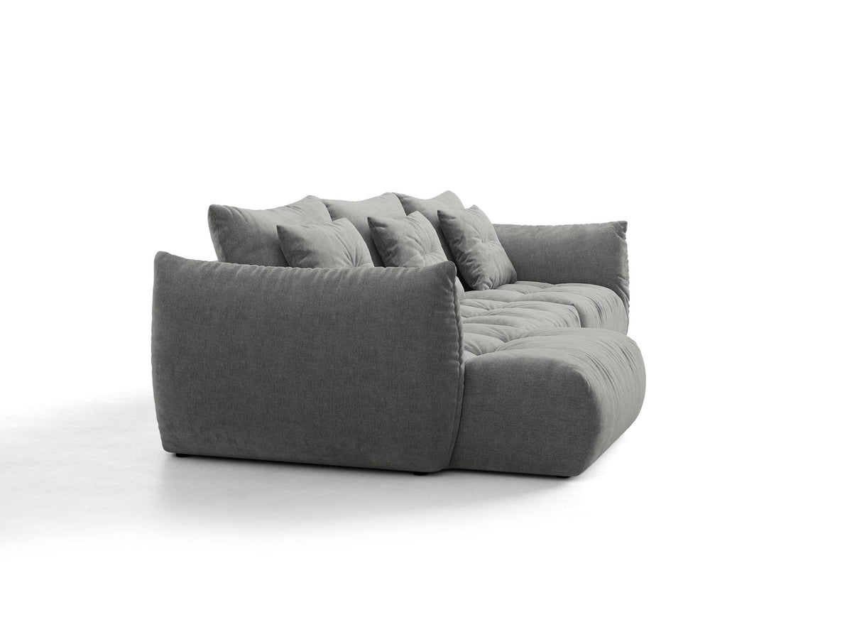 Beiges L-Sofa links von Micadoni mit weichem Veloursstoff Casino, schwarzen Kunststoffbeinen und breiter, tiefer Sitzfläche.