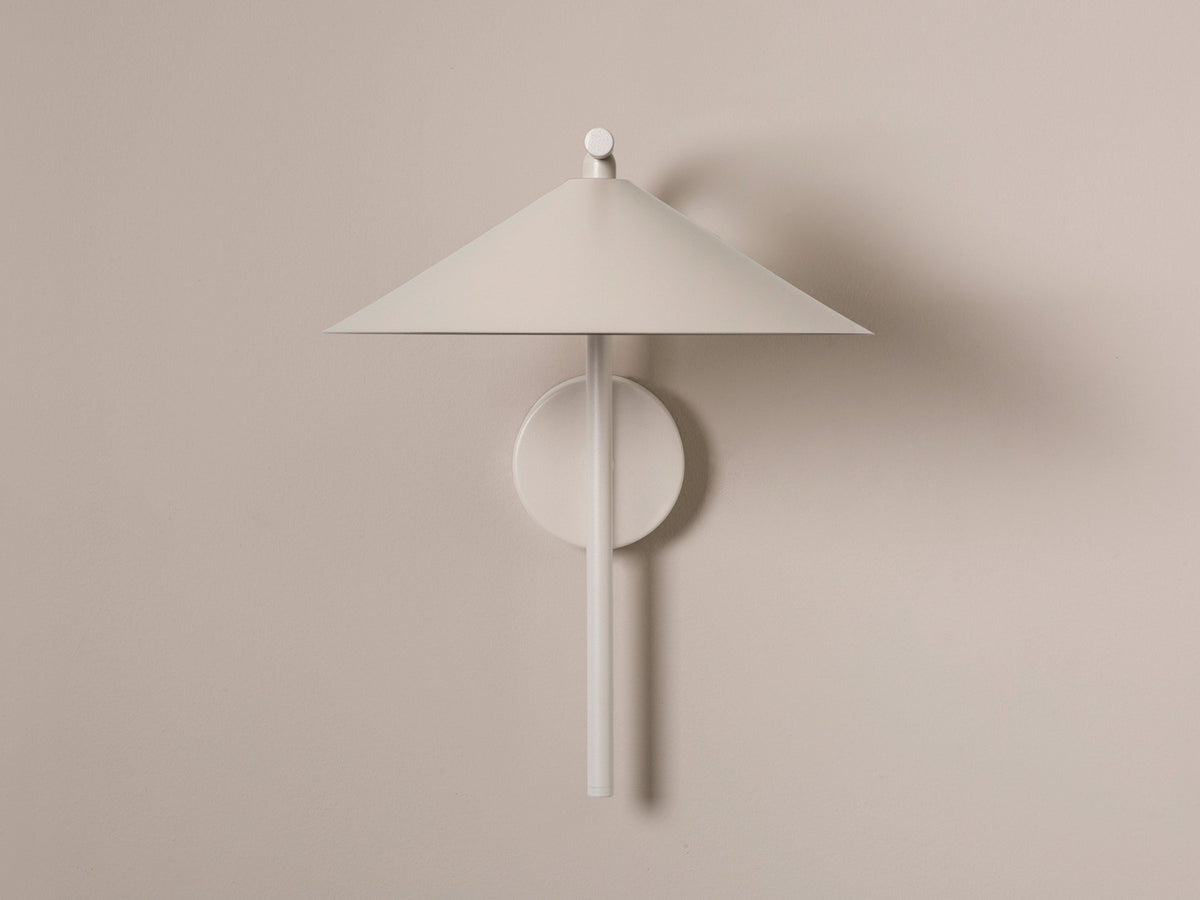 Wandlampe Nocte von Micadoni in Burgundfarben, konische Form aus mattem Metall, montiert an einer hellen Wand im Wohnraum.