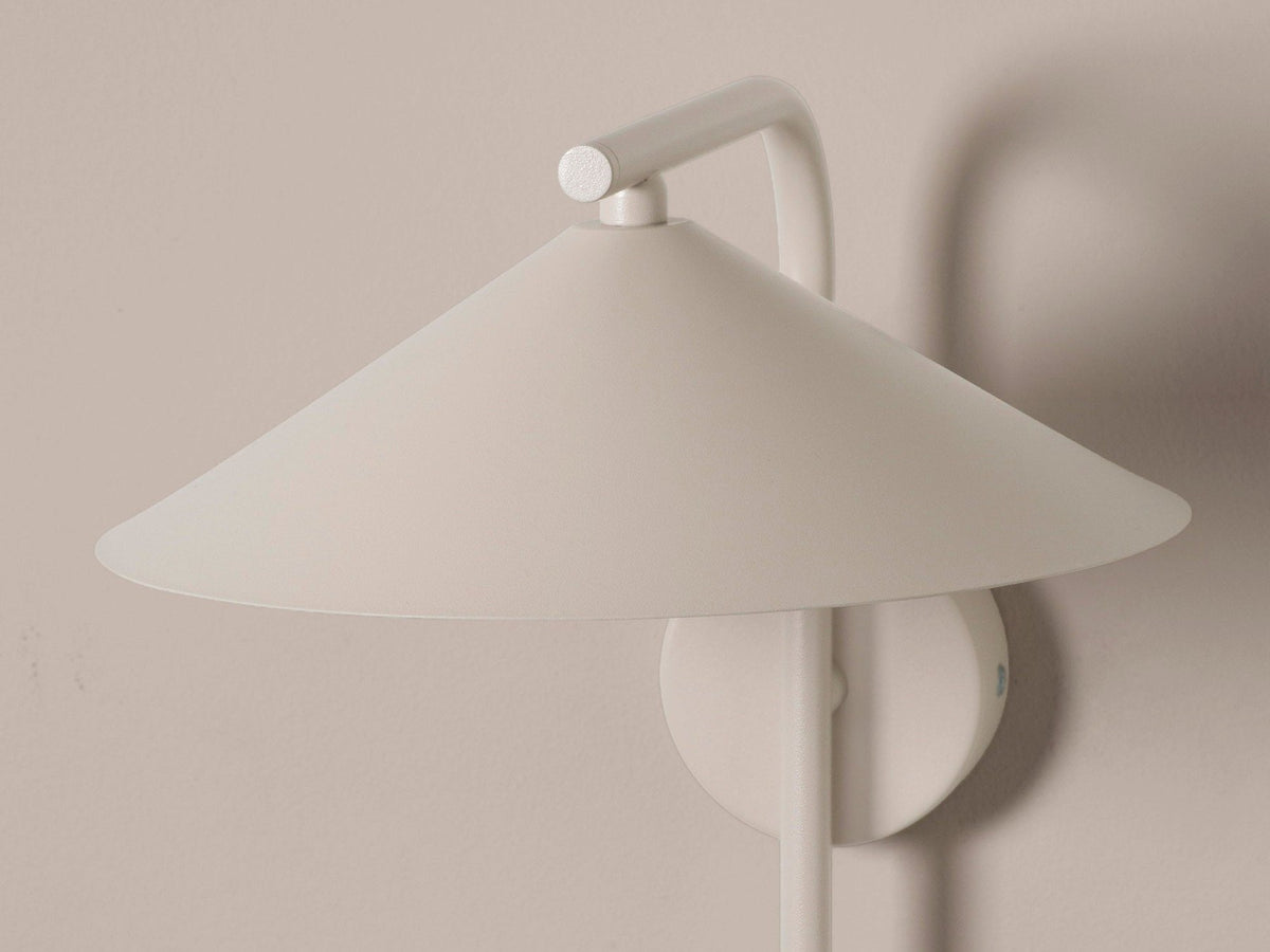 Wandlampe Nocte von Micadoni in Burgundfarben, konische Form aus mattem Metall, montiert an einer hellen Wand im Wohnraum.