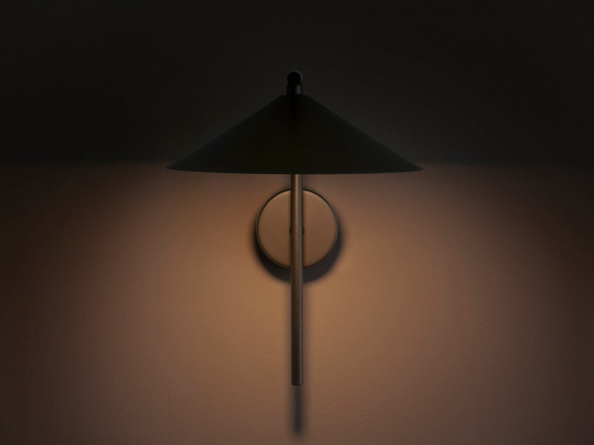 Wandlampe Nocte von Micadoni in Burgundfarben, konische Form aus mattem Metall, montiert an einer hellen Wand im Wohnraum.