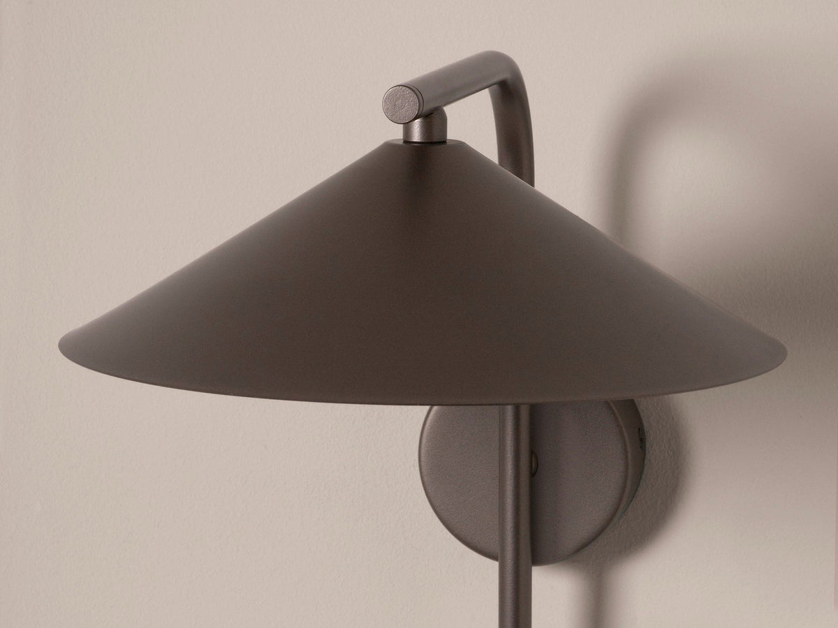 Wandlampe Nocte von Micadoni in Burgundfarben, konische Form aus mattem Metall, montiert an einer hellen Wand im Wohnraum.