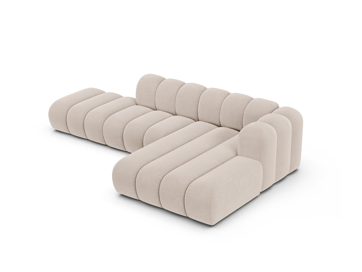 Beiges L-Sofa Lupine von Micadoni mit Venus-Samtstoffbezug, schwarzen Kunststoffbeinen und rechter Ausrichtung, Grösse 299x177x70 cm.