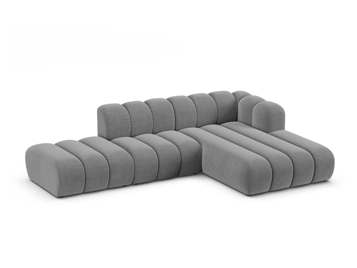 Beiges L-Sofa Lupine von Micadoni mit Venus-Samtstoffbezug, schwarzen Kunststoffbeinen und rechter Ausrichtung, Grösse 299x177x70 cm.