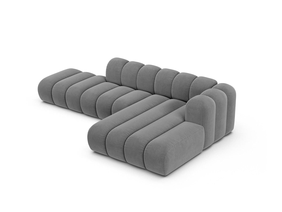 Beiges L-Sofa Lupine von Micadoni mit Venus-Samtstoffbezug, schwarzen Kunststoffbeinen und rechter Ausrichtung, Grösse 299x177x70 cm.