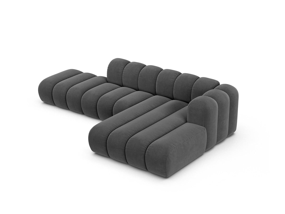 Beiges L-Sofa Lupine von Micadoni mit Venus-Samtstoffbezug, schwarzen Kunststoffbeinen und rechter Ausrichtung, Grösse 299x177x70 cm.