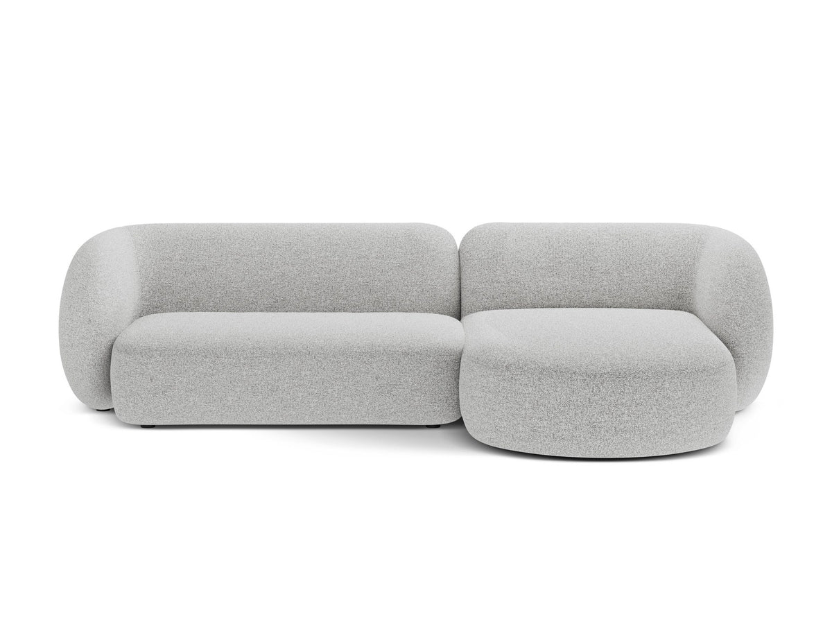 Weisses Ecksofa rechts Kate von Micadoni mit strukturiertem Bouclé-Stoff, schwarzen Kunststoffbeinen und niedriger Rückenlehne.