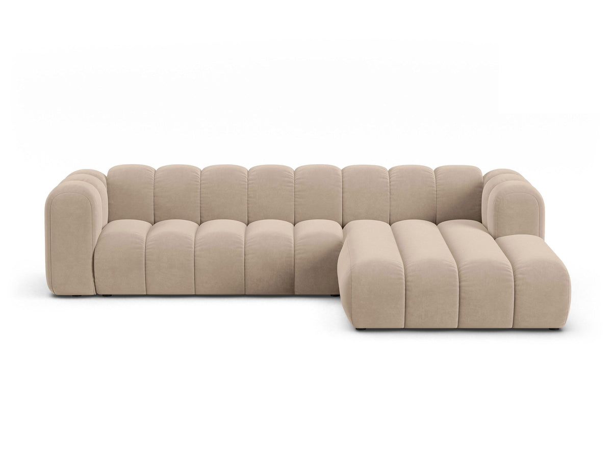 Linksseitig ausgerichtetes Ecksofa Lupine mit Samtbezug in leichtem Beige, schwarzen Kunststoffbeinen und tiefer Sitzfläche, Frontalansicht