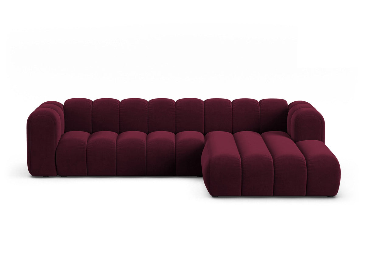 Linksseitig ausgerichtetes Ecksofa Lupine mit Samtbezug in leichtem Beige, schwarzen Kunststoffbeinen und tiefer Sitzfläche, Frontalansicht