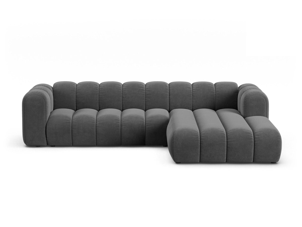 Linksseitig ausgerichtetes Ecksofa Lupine mit Samtbezug in leichtem Beige, schwarzen Kunststoffbeinen und tiefer Sitzfläche, Frontalansicht