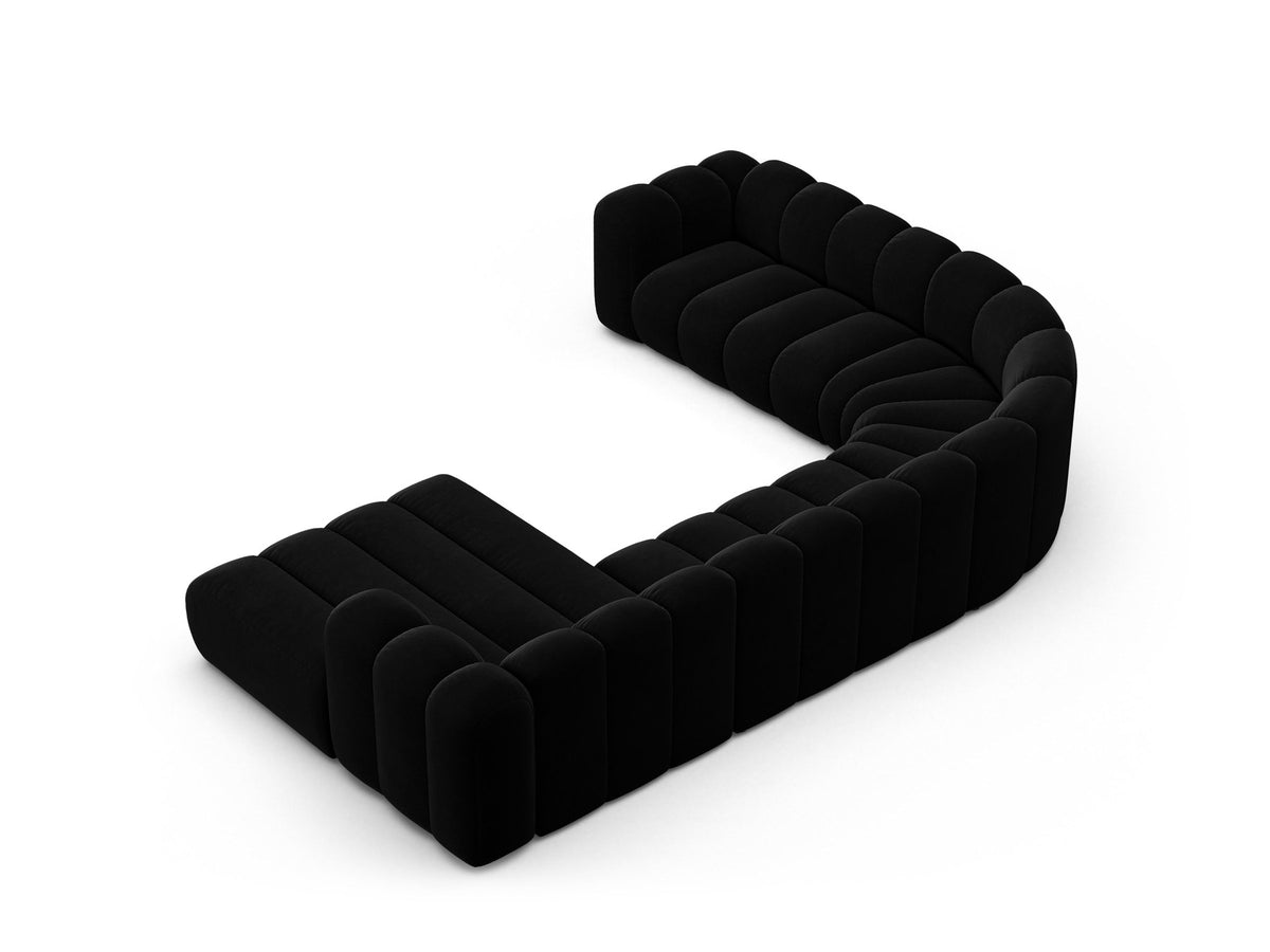 Foto eines modularen Ecksofas links in leichtem Beige aus Samtstoff Venus, mit schwarzen Kunststoffbeinen und breiter Sitzfläche.