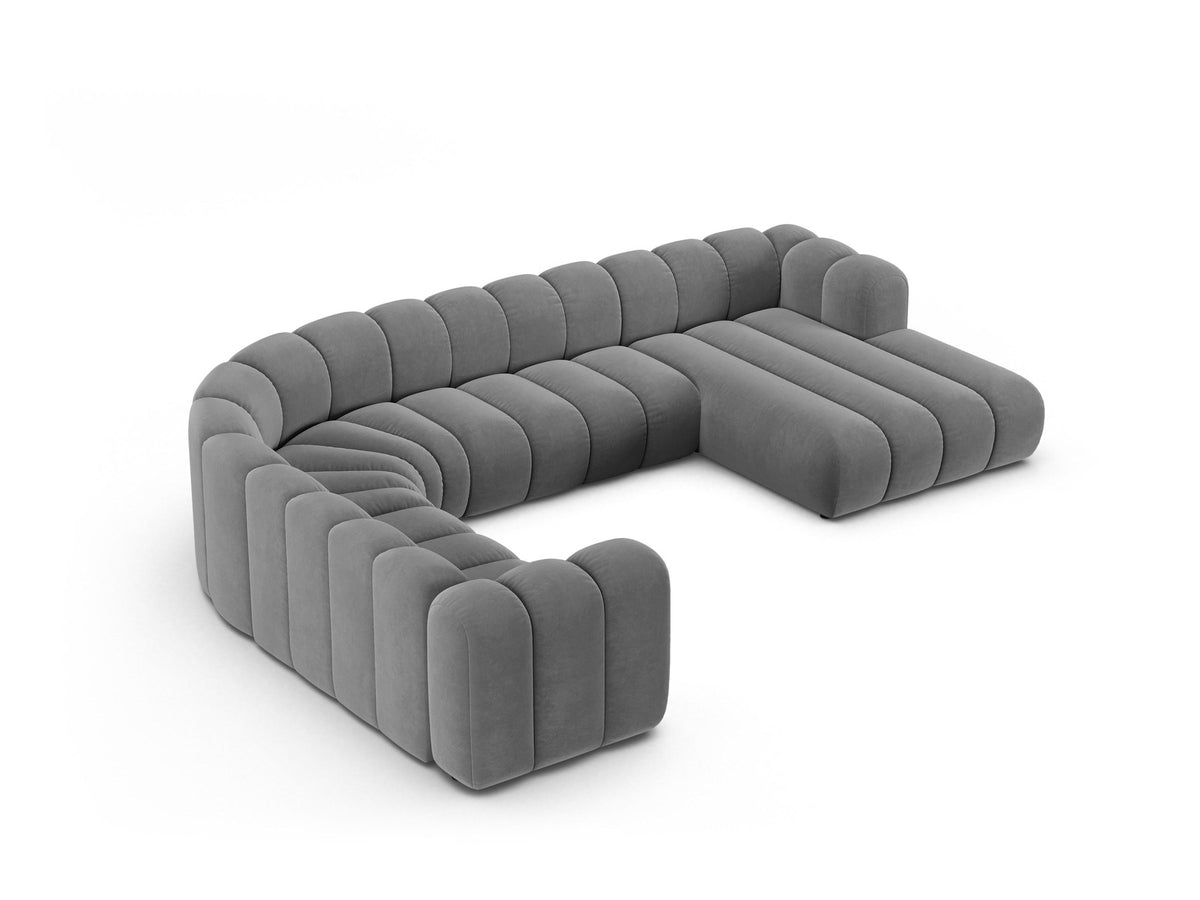 Foto eines modularen Ecksofas links in leichtem Beige aus Samtstoff Venus, mit schwarzen Kunststoffbeinen und breiter Sitzfläche.