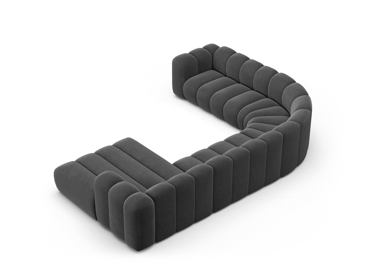 Foto eines modularen Ecksofas links in leichtem Beige aus Samtstoff Venus, mit schwarzen Kunststoffbeinen und breiter Sitzfläche.