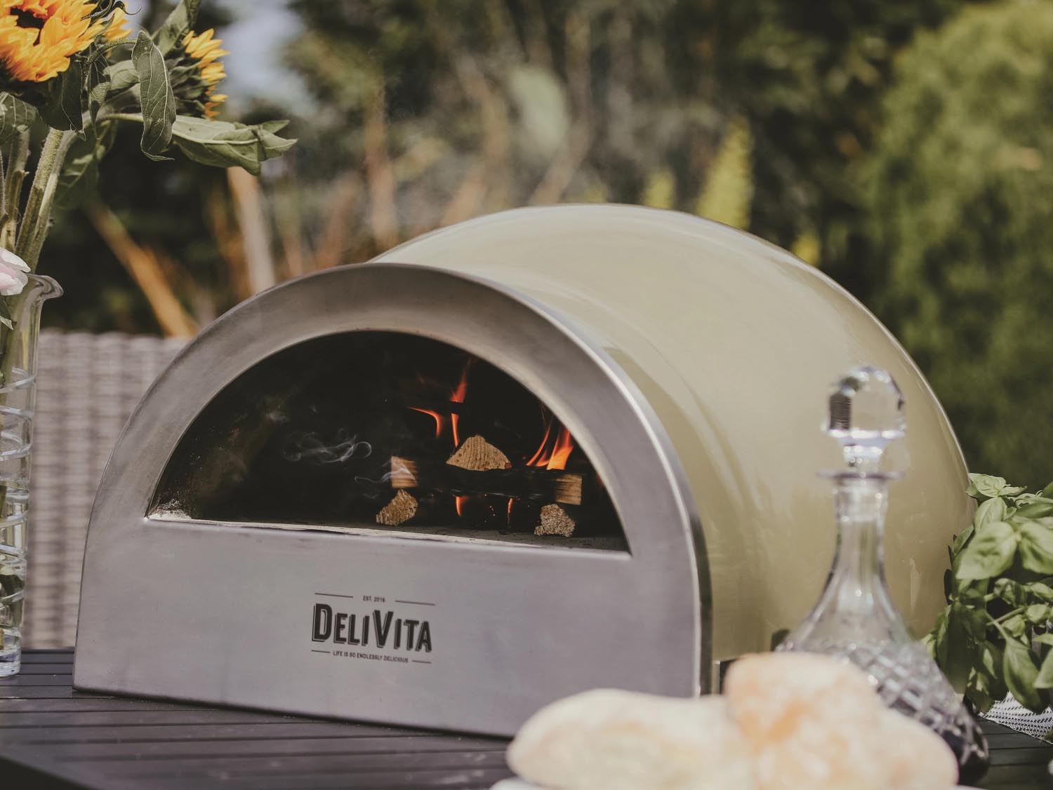 Der olivgrüne Delivita Ofen ist ein eleganter Holzofen, perfekt für Pizza und vielseitiges Kochen im Freien.