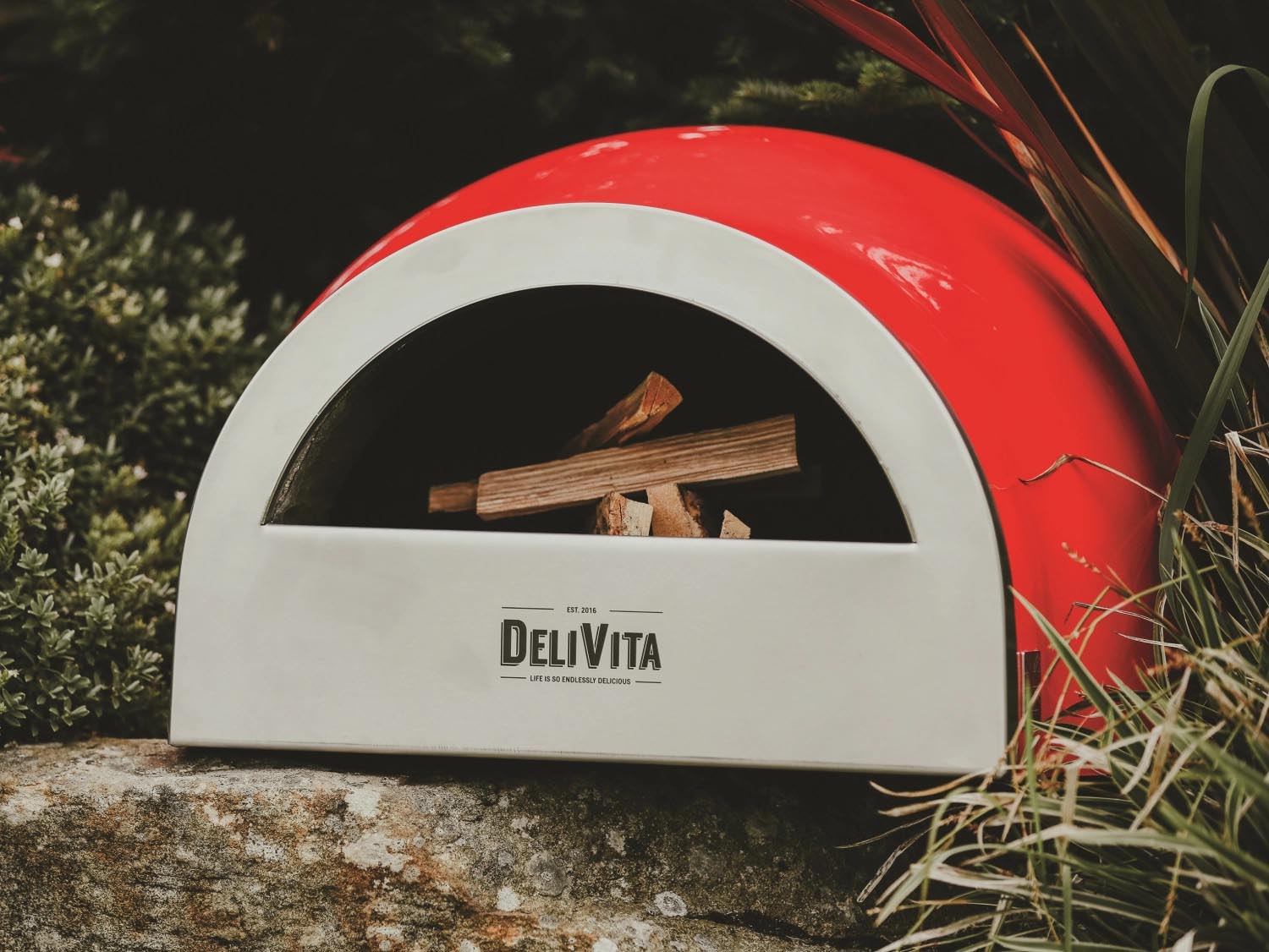 Der tragbare Delivita Ofen in Chilirot bietet stilvolles Design und Funktionalität für Pizza und kulinarische Kreationen.