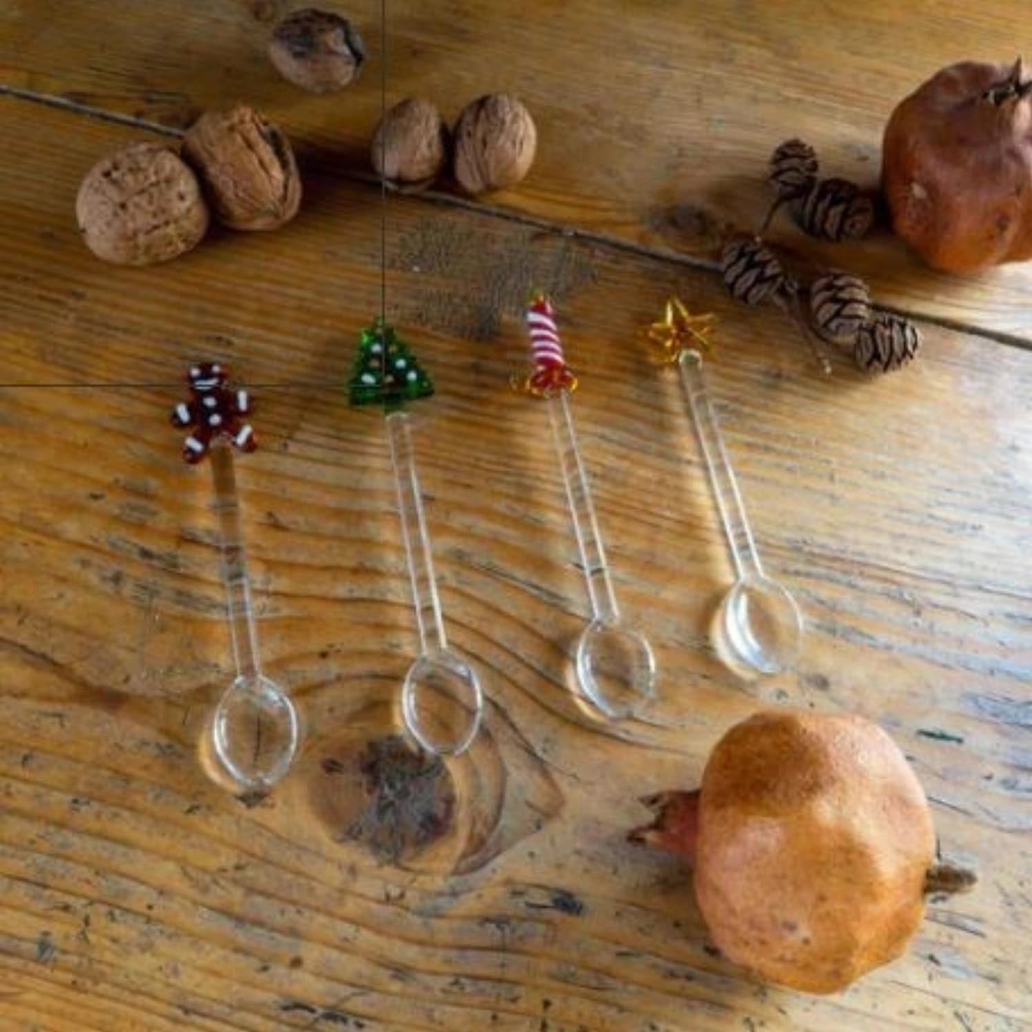 Set aus 4 Teelöffeln aus Glas mit weihnachtlichen Motiven, perfekt für die Festtage und als stilvolles Geschenk geeignet.