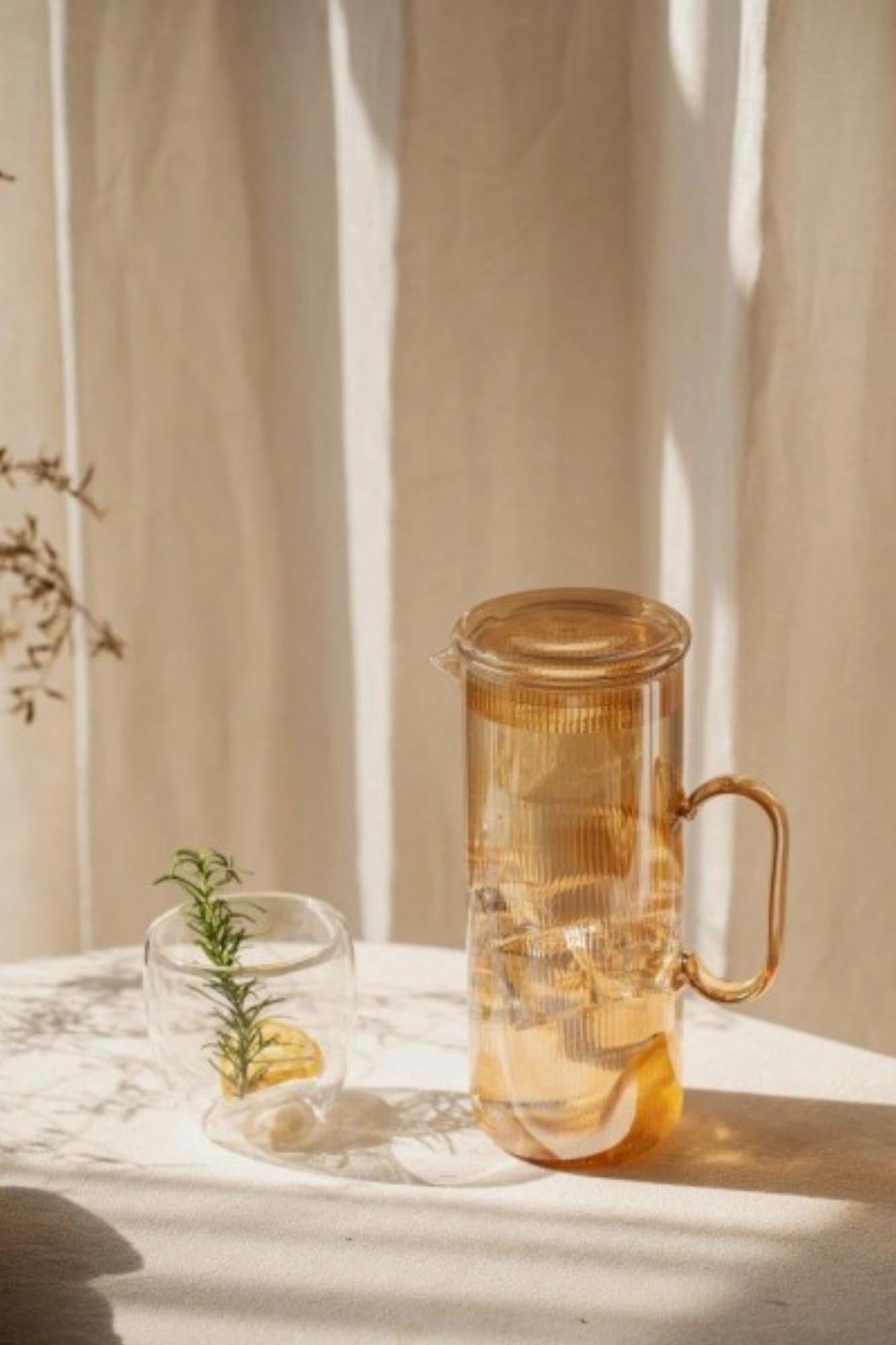 Stilvolle 1.2l Karaffe aus robustem Borosilikatglas mit edlem goldfarbenem Detail, perfekt für elegante Getränkeservierung.