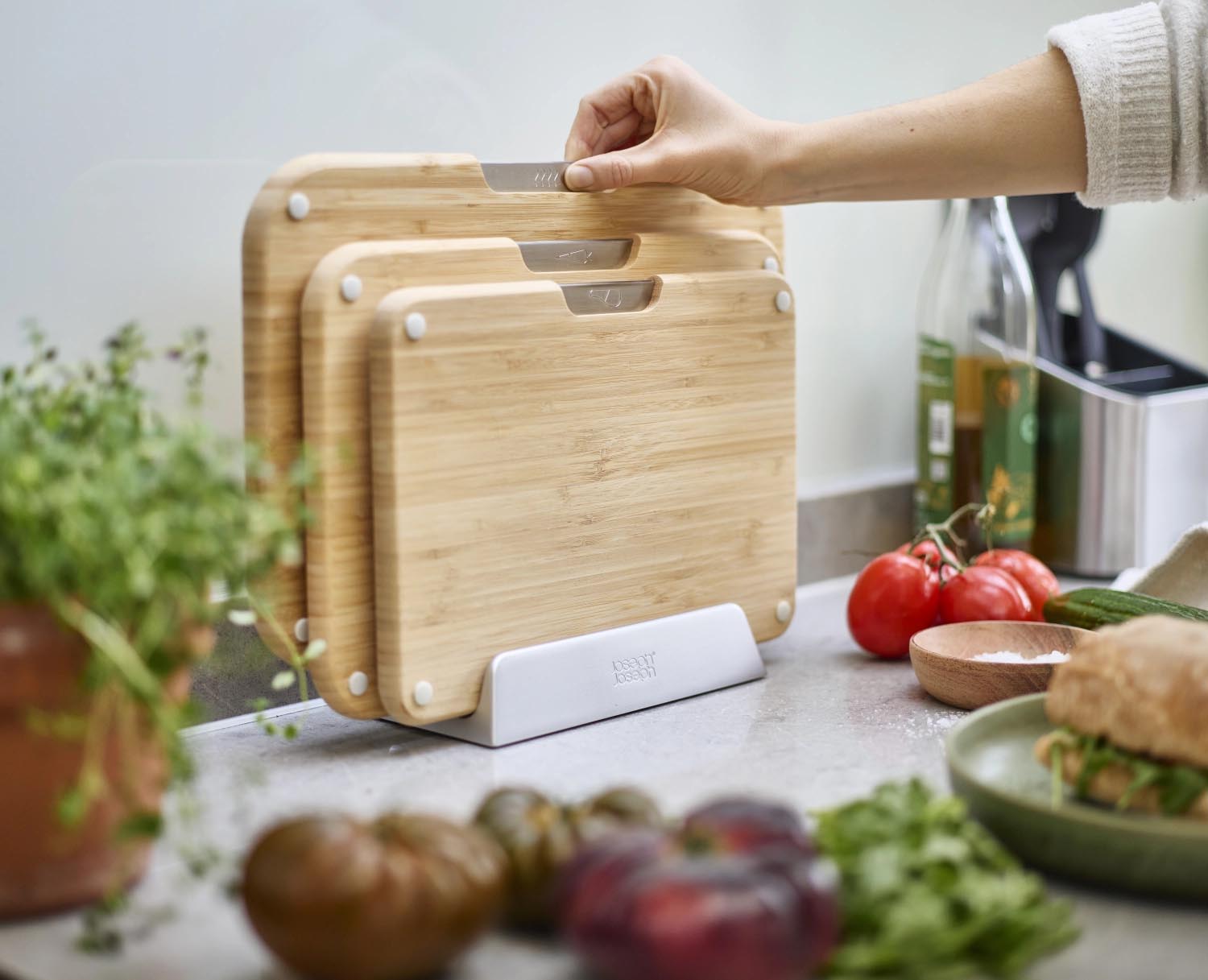 Praktisches 3er-Set Bambus-Schneidbretter mit Halterung von Joseph Joseph, ideal für hygienisches und organisiertes Arbeiten in der Küche.