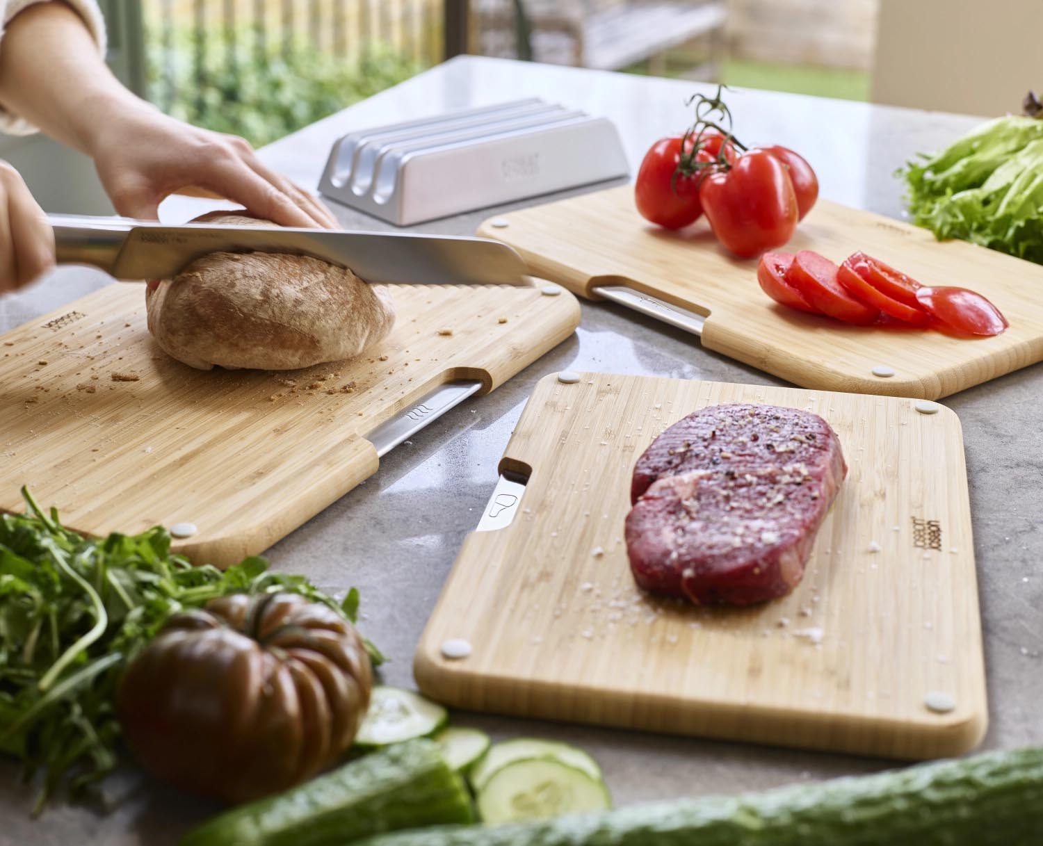 Erleben Sie das 3er Set Nest Boards von Joseph Joseph: Hochwertige, zweiseitige Bambus-Schneidbretter mit elegantem Halter für sichere und hygienische Zubereitung.
