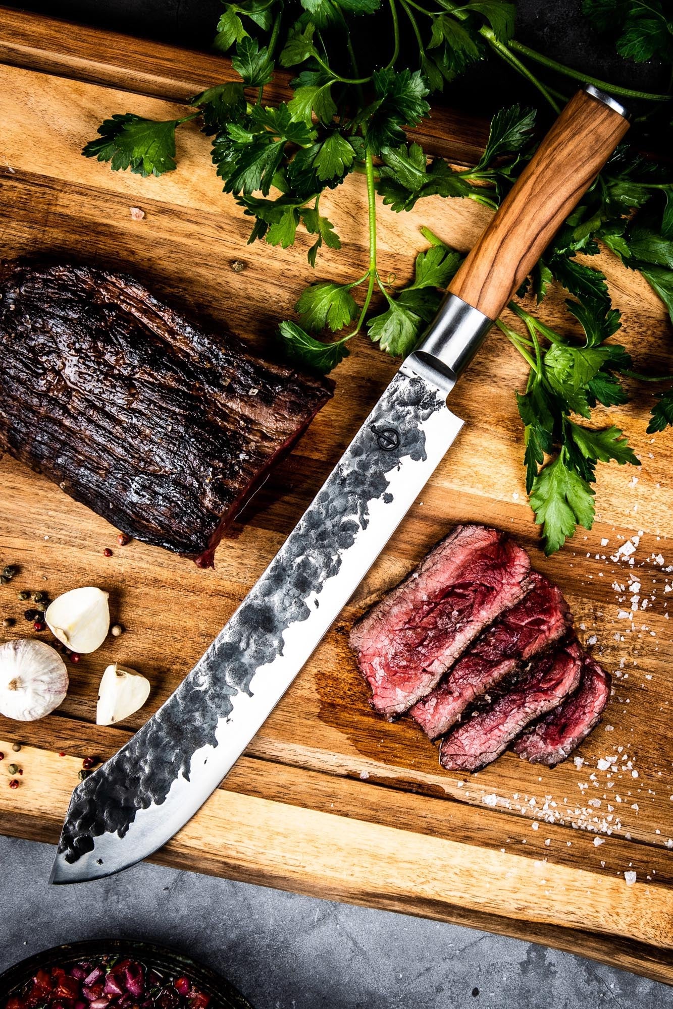 Das 25cm Forged Olive Metzgermesser kombiniert eine scharfe Klinge mit einem stilvollen Griff aus Olivenholz.