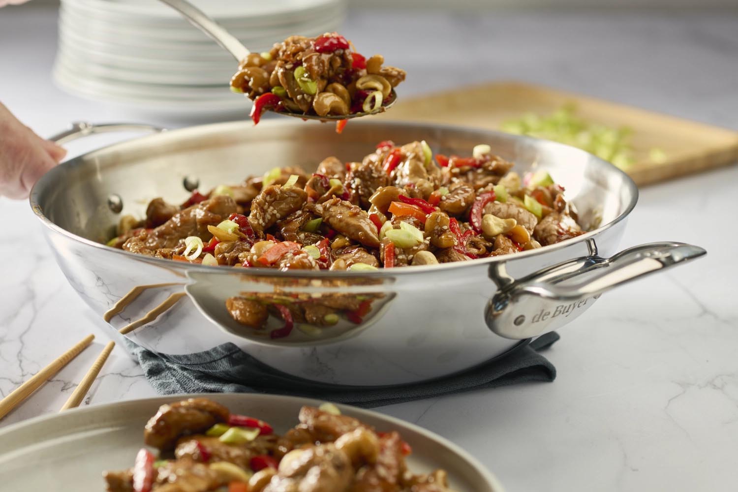 Hochwertiger Edelstahl-Wok von de Buyer, 32 cm, mit zwei Griffen, ideal für gleichmässiges Kochen und vielseitige Gerichte.