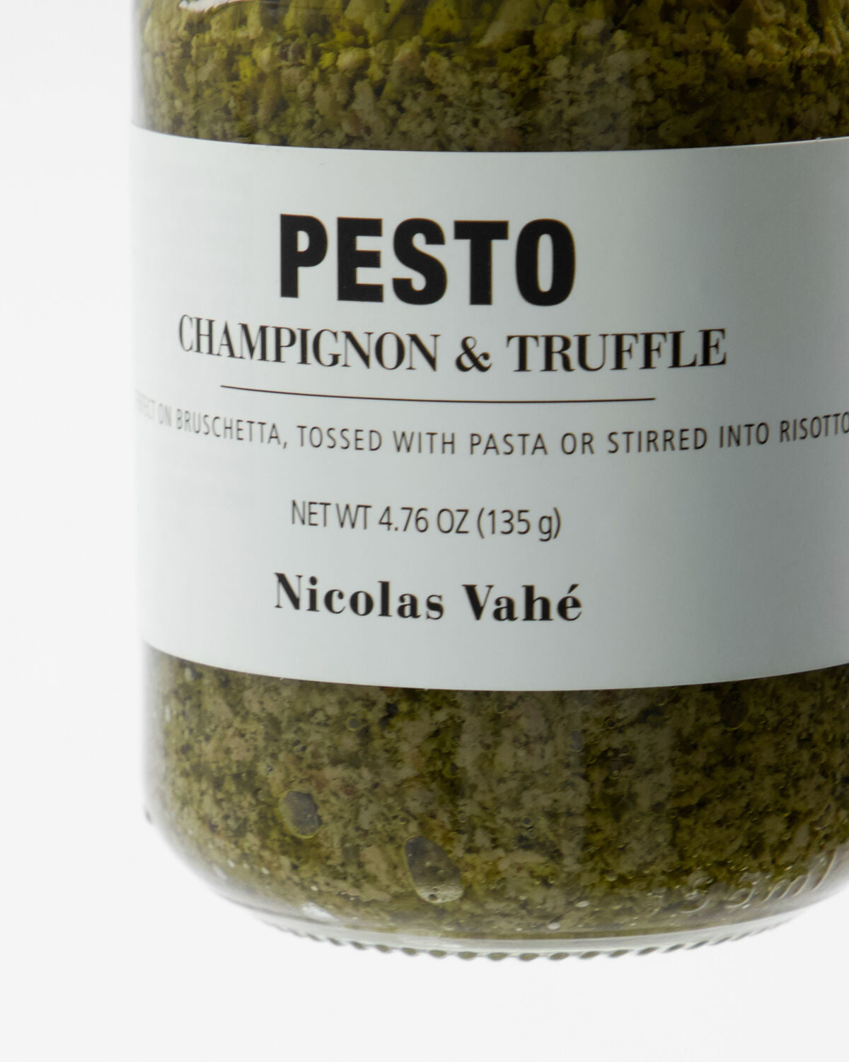 Ein elegantes Glas Pesto mit Champignons und Trüffel von Nicolas Vahé, 135 g, umgeben von frischen Kräutern und Zutaten auf einem rustikalen Holzbrett.