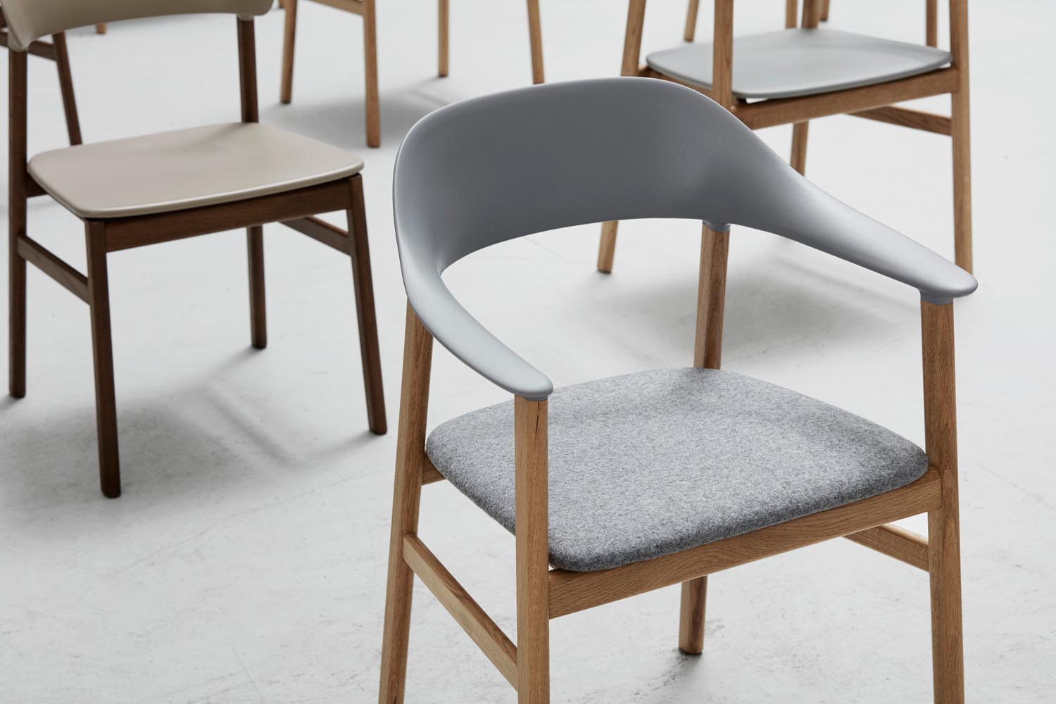 Der Herit Stuhl mit Armlehnen von Normann Copenhagen vereint elegantes Design mit optimalem Komfort, perfekt für moderne Wohnräume.
