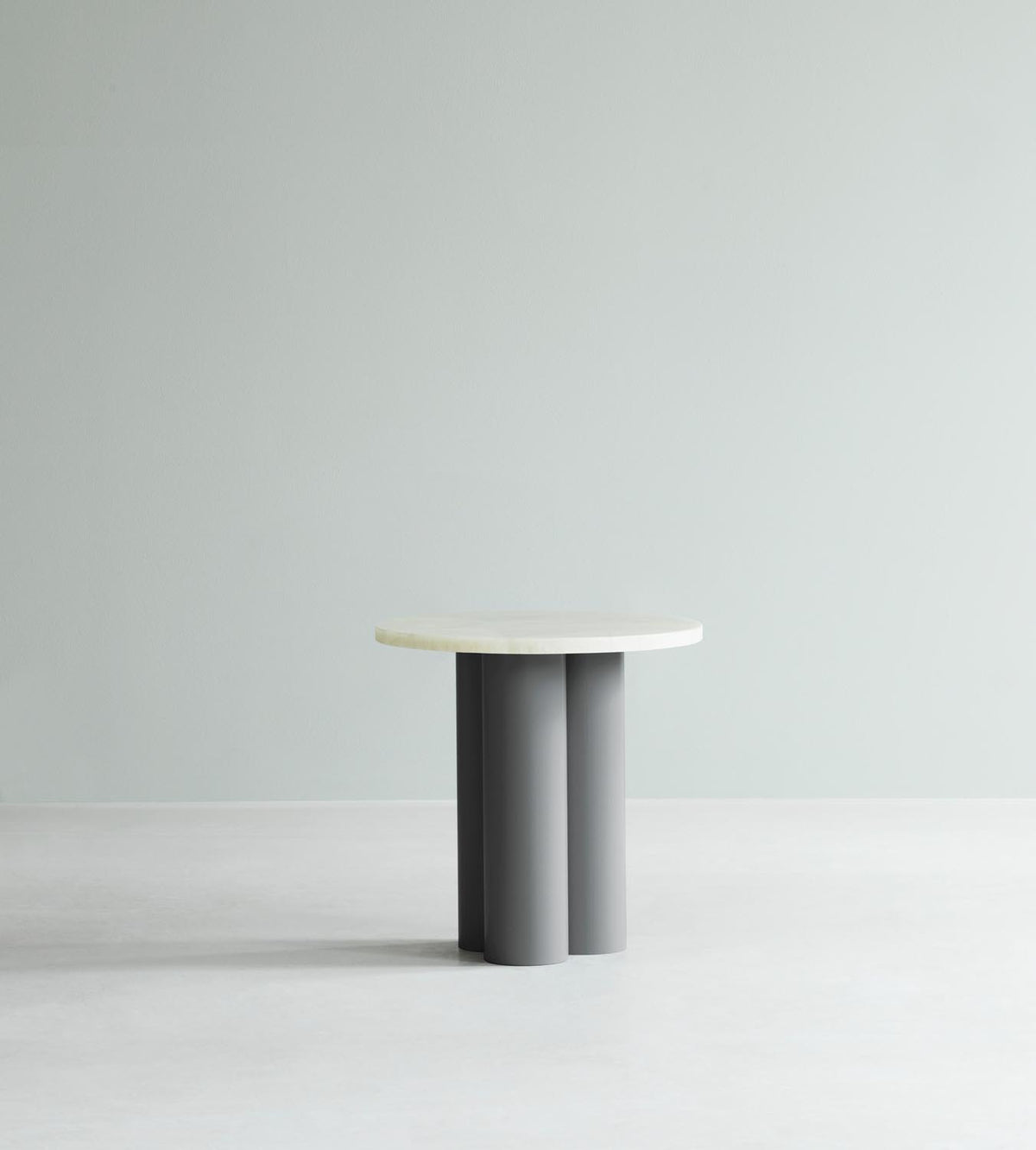 Beistelltisch Dit von Normann Copenhagen mit runder Tischplatte aus Stein in Sand Travertine Light, getragen von drei zylindrischen Stahlbeinen.