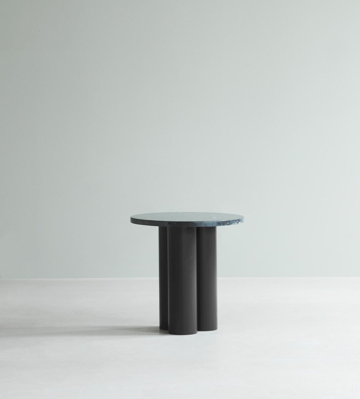 Beistelltisch Dit von Normann Copenhagen mit runder Tischplatte aus Stein in Sand Travertine Light, getragen von drei zylindrischen Stahlbeinen.
