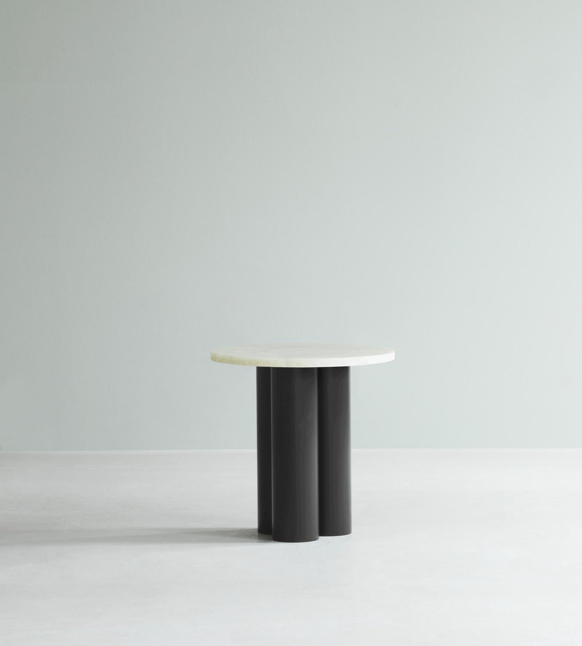 Beistelltisch Dit von Normann Copenhagen mit runder Tischplatte aus Stein in Sand Travertine Light, getragen von drei zylindrischen Stahlbeinen.