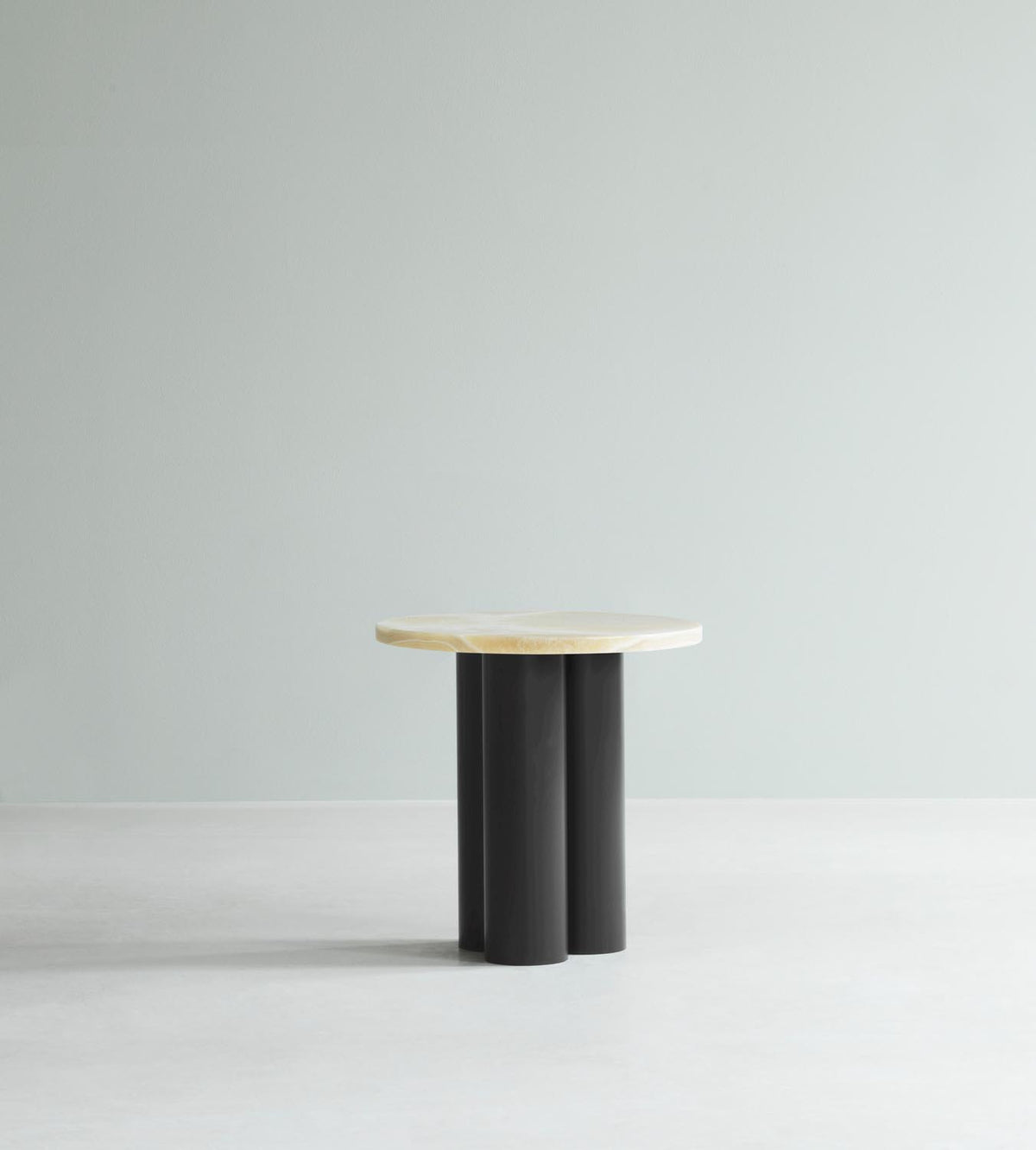 Beistelltisch Dit von Normann Copenhagen mit runder Tischplatte aus Stein in Sand Travertine Light, getragen von drei zylindrischen Stahlbeinen.