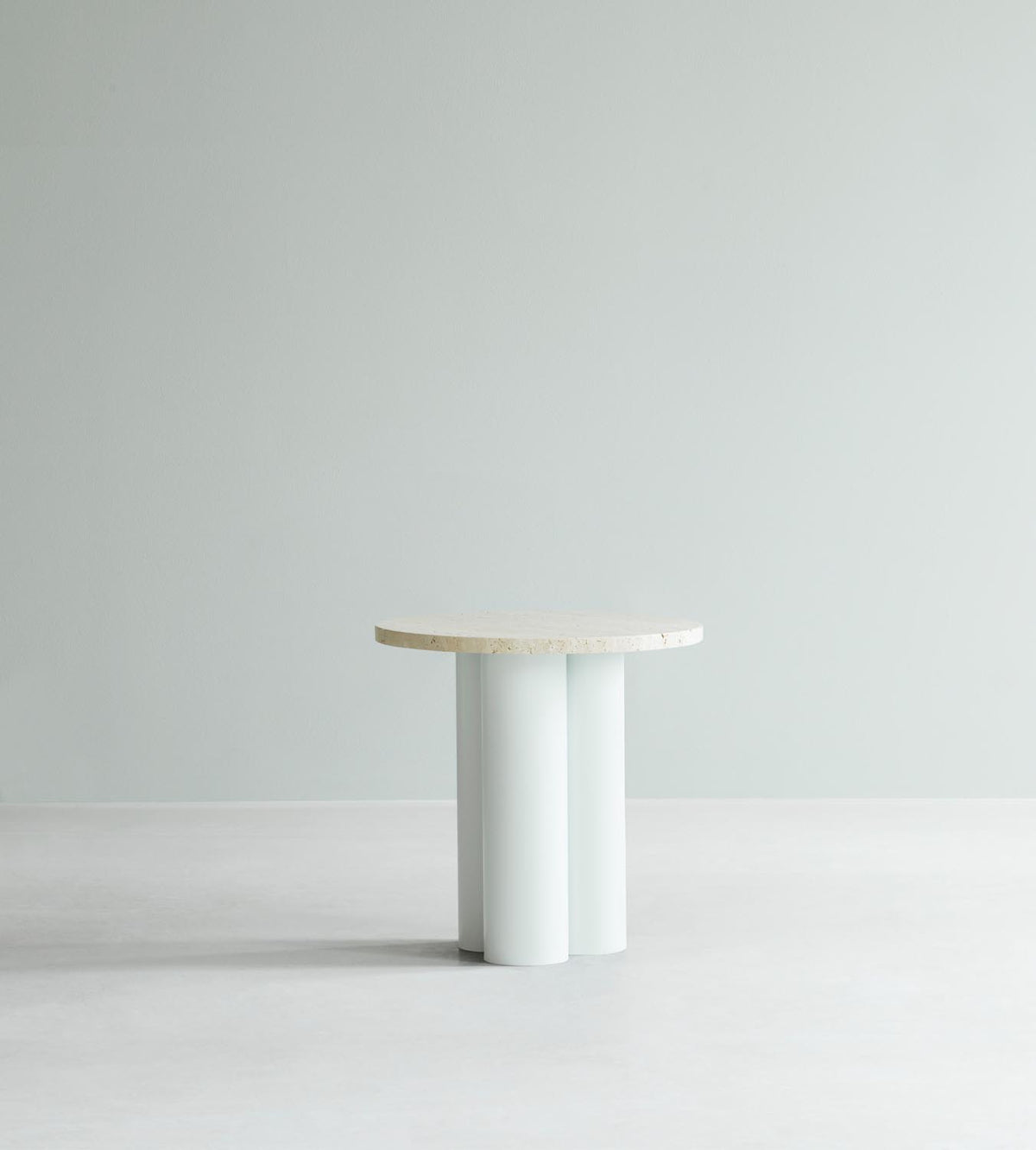 Beistelltisch Dit von Normann Copenhagen mit runder Tischplatte aus Stein in Sand Travertine Light, getragen von drei zylindrischen Stahlbeinen.