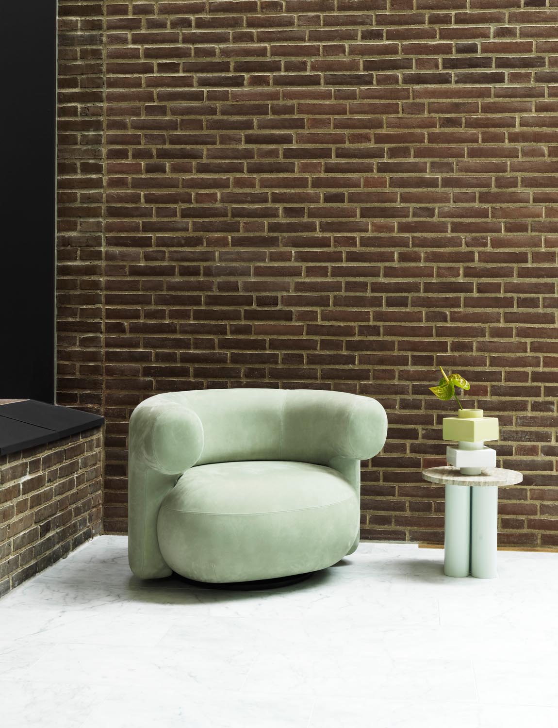 Beistelltisch Dit von Normann Copenhagen mit runder Tischplatte aus Stein in Sand Travertine Light, getragen von drei zylindrischen Stahlbeinen.