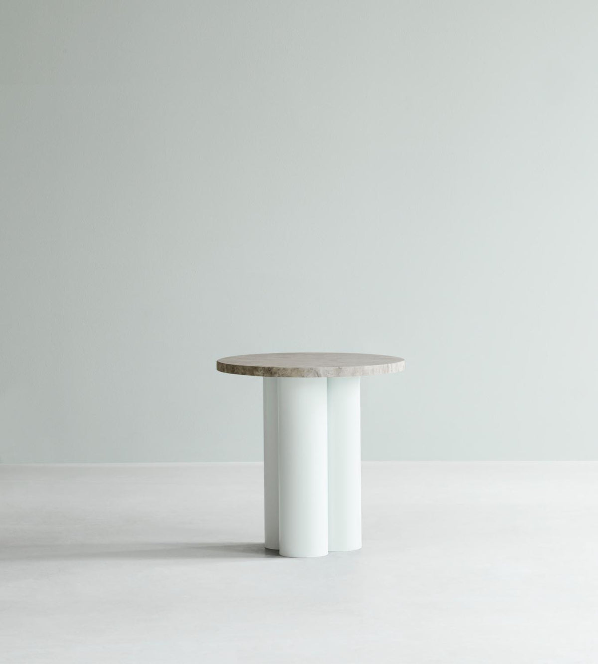 Beistelltisch Dit von Normann Copenhagen mit runder Tischplatte aus Stein in Sand Travertine Light, getragen von drei zylindrischen Stahlbeinen.