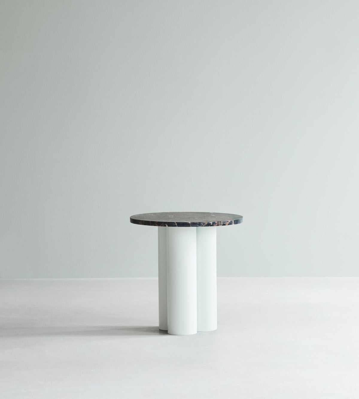 Beistelltisch Dit von Normann Copenhagen mit runder Tischplatte aus Stein in Sand Travertine Light, getragen von drei zylindrischen Stahlbeinen.