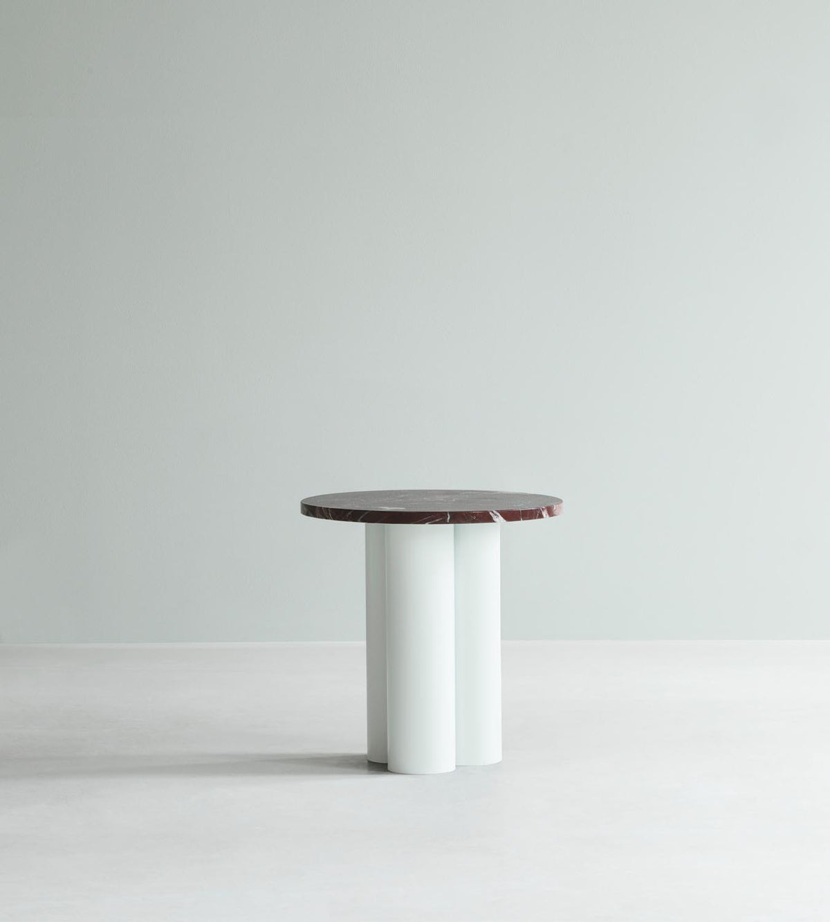 Beistelltisch Dit von Normann Copenhagen mit runder Tischplatte aus Stein in Sand Travertine Light, getragen von drei zylindrischen Stahlbeinen.
