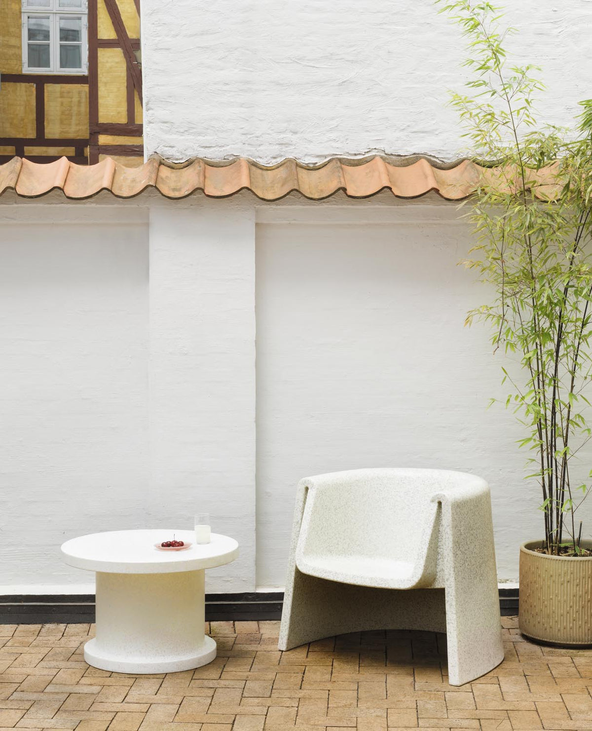 Weisser Bit Loungesessel mit Armlehnen von Normann Copenhagen, hergestellt aus recyceltem Kunststoff mit pixeliger Oberflächenstruktur.