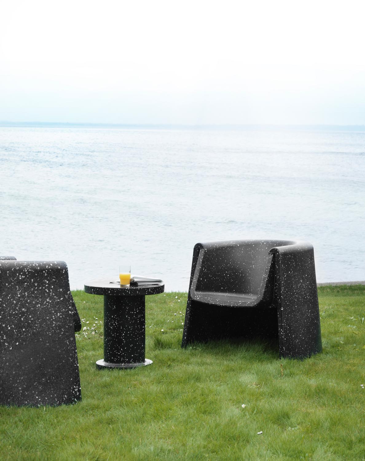 Weisser Bit Loungesessel mit Armlehnen von Normann Copenhagen, hergestellt aus recyceltem Kunststoff mit pixeliger Oberflächenstruktur.