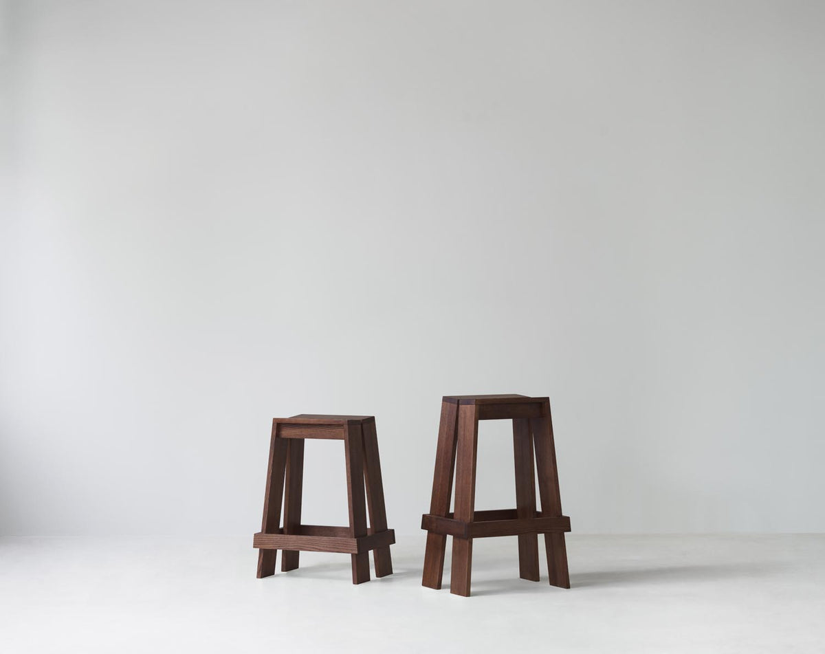 Barhocker Let 65 cm von Normann Copenhagen aus lackierter Eiche mit zwei parallelen, leicht geneigten Holzbrettern als Sitzfläche.