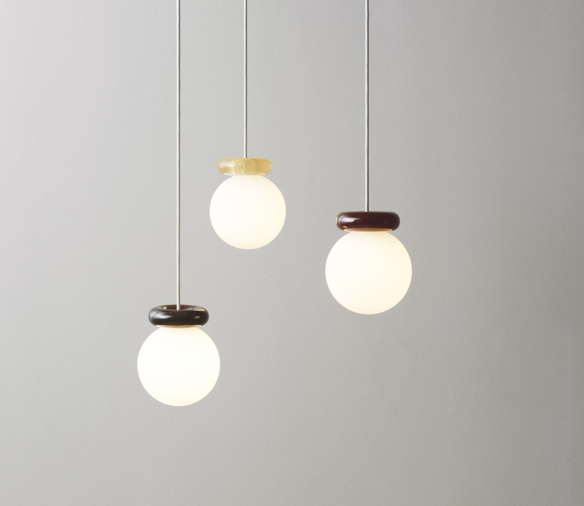 Pendelleuchte Hinx von Normann Copenhagen in Dunkelbraun, Lampenschirm aus Opalglas mit ringförmigem Kunstharzsockel.