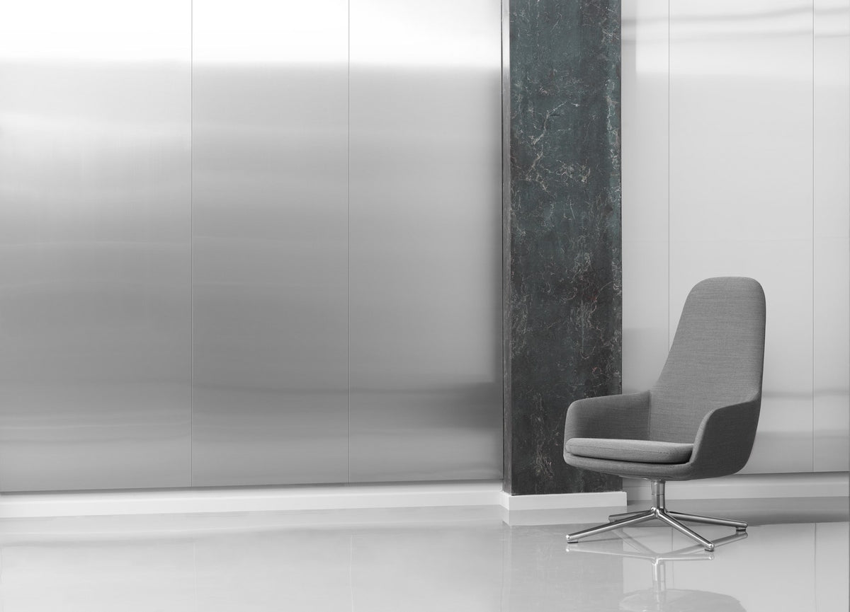 Era Lounge-Sessel hoch von Normann Copenhagen in Grau mit gepolsterter, geschwungener Rückenlehne und drehbarem Alu-Gestell.