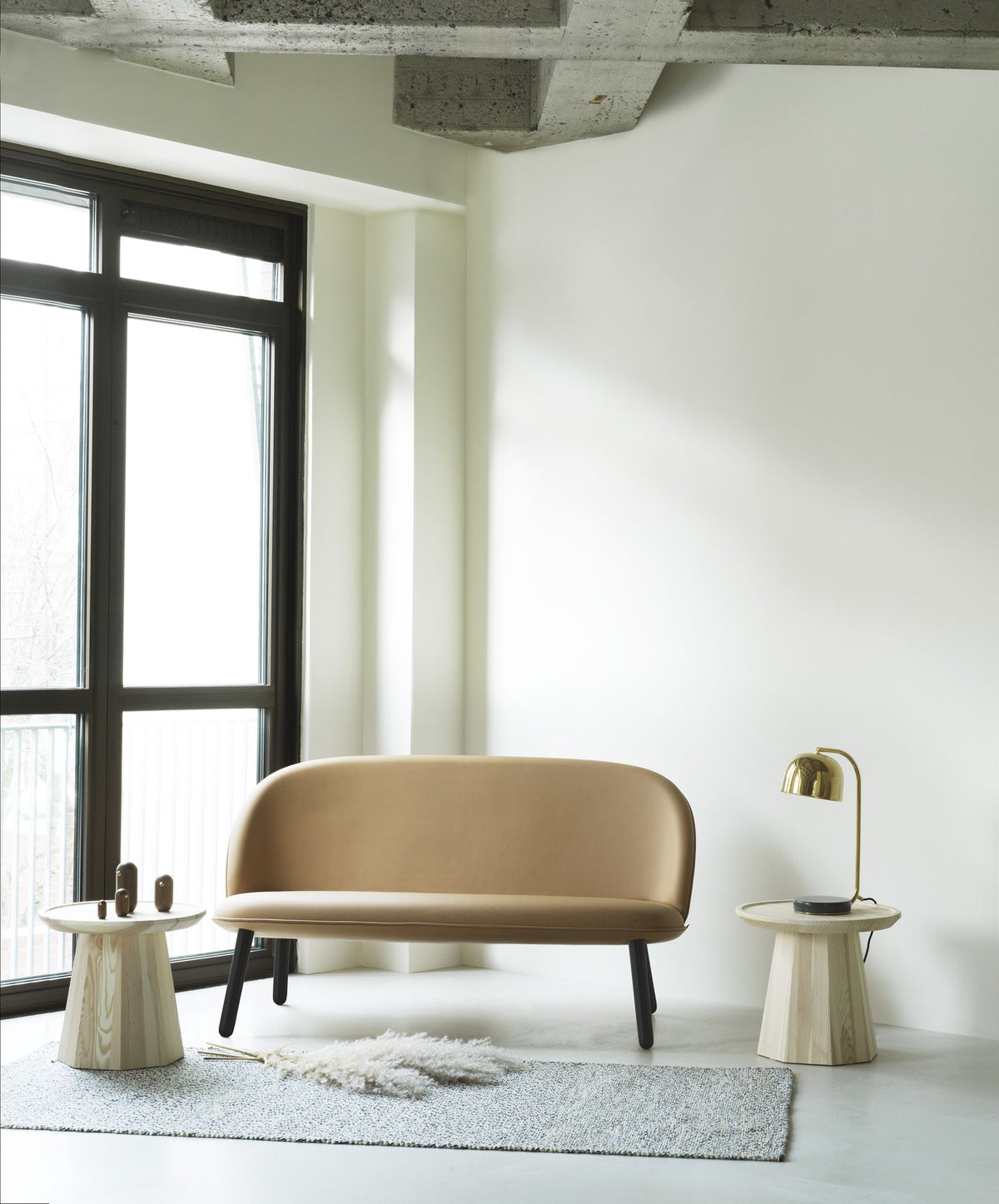 Ace Sofa Messing von Normann Copenhagen: Beiges 2er Sofa mit gepolsterter Rückenlehne, Sitzfläche und konischen Beinen aus Messing.