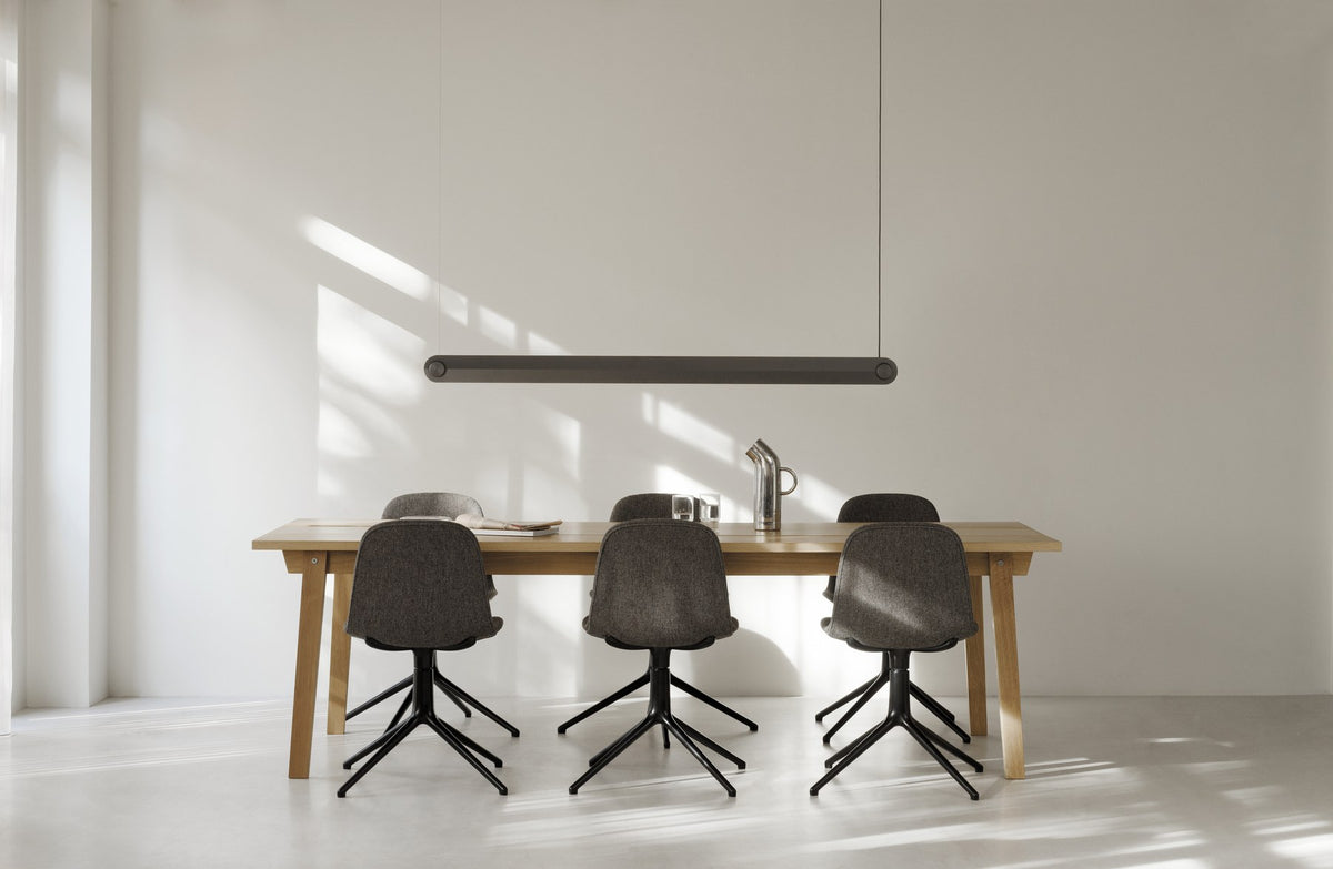 Schwarzer, gepolsterter Drehstuhl Form von Normann Copenhagen mit Schale aus Polypropylen und Drehsockel aus Aluminium mit vier Rädern.