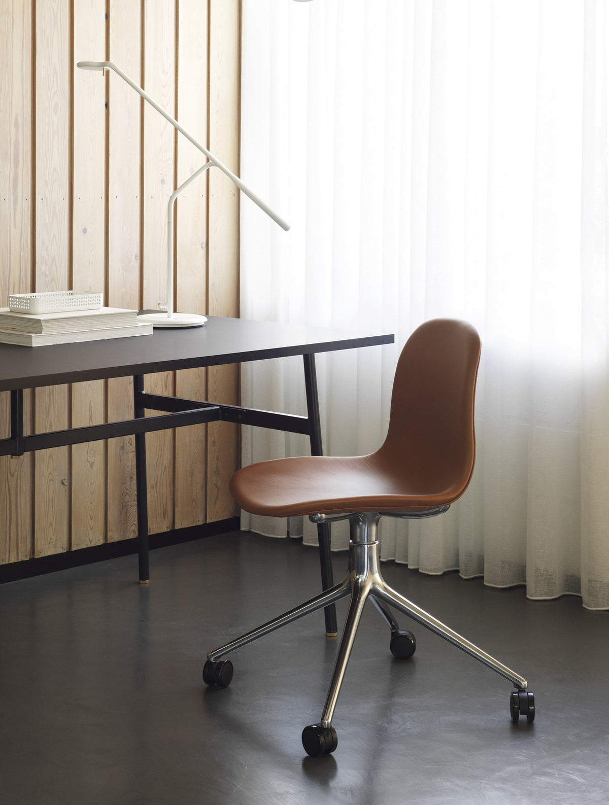 Form Drehstuhl von Normann Copenhagen mit brauner Polsterung, Sitzschale aus Polypropylen und Drehgestell aus Aluminium mit vier Rollen.