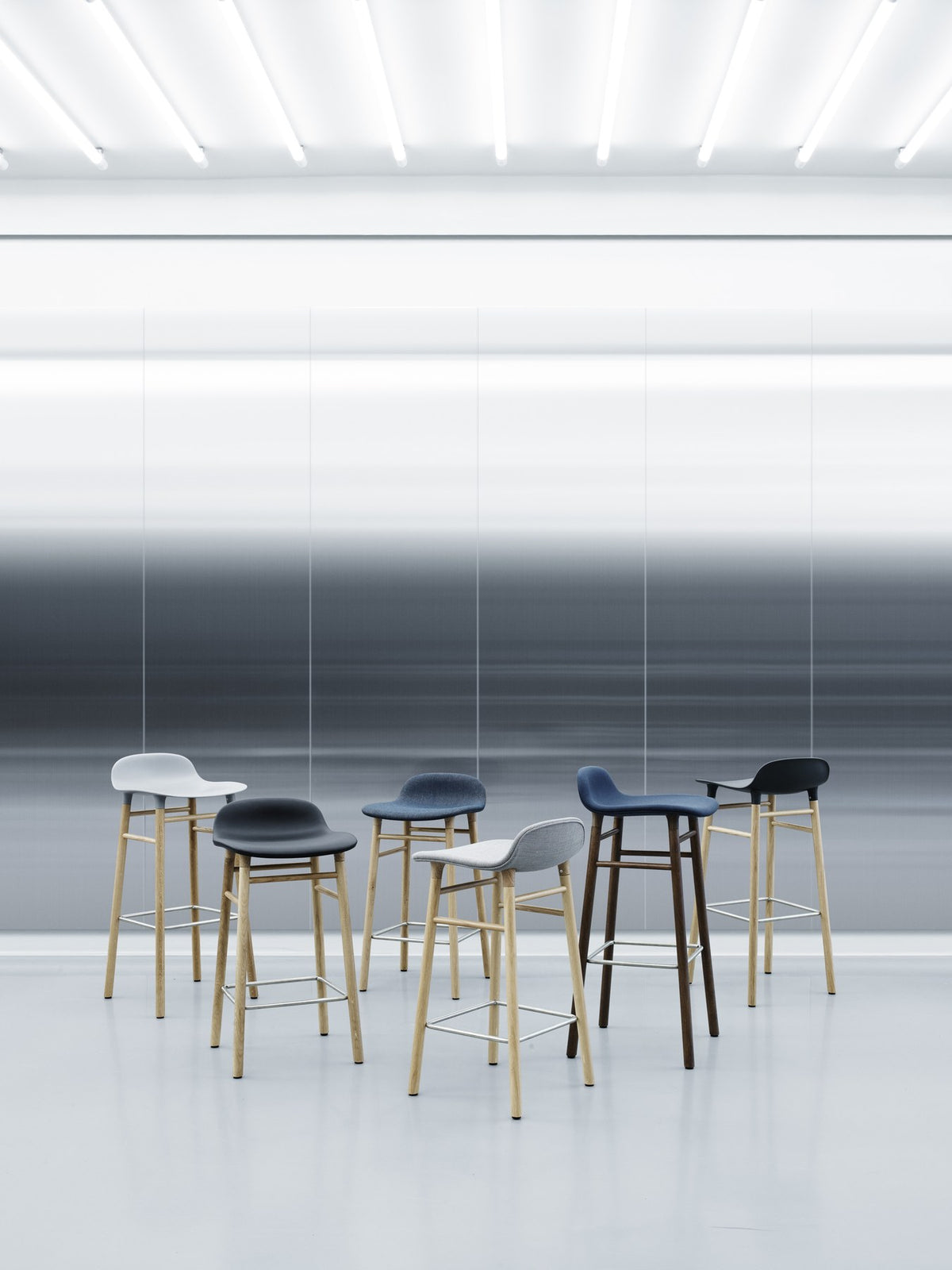 Form Barstuhl von Normann Copenhagen mit blau gepolsterter Sitzschale und Beinen aus lackiertem Walnussholz, Sitzhöhe 65 cm.
