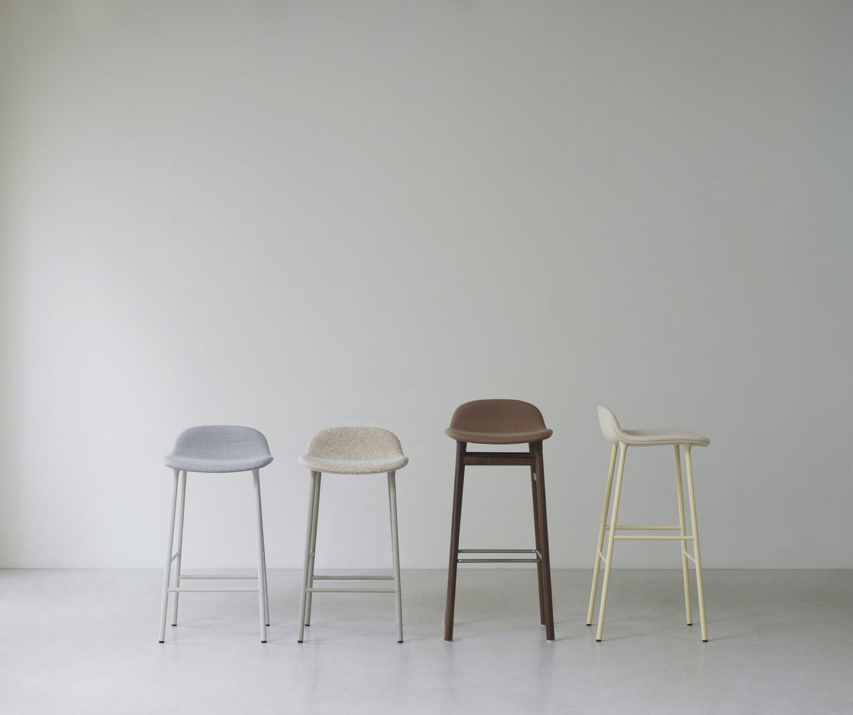 Grauer Barstuhl Form von Normann Copenhagen mit gepolsterter Sitzschale, Stahlbeinen und Sitzhöhe 65 cm.