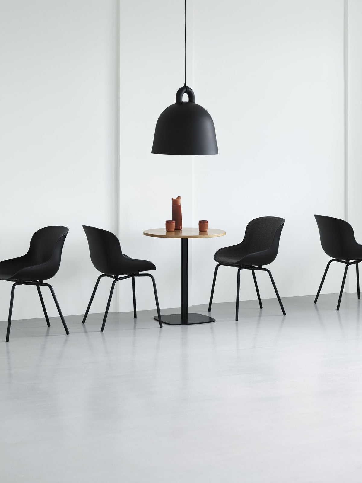 Hyg Stuhl von Normann Copenhagen in Grau: Schale aus Polypropylen mit Frontpolster, Gestell aus Stahl, organisch geschwungene Form.